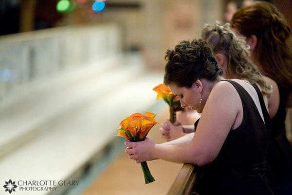 Bridesmaids in brown dresses with mango calla lily bouquets