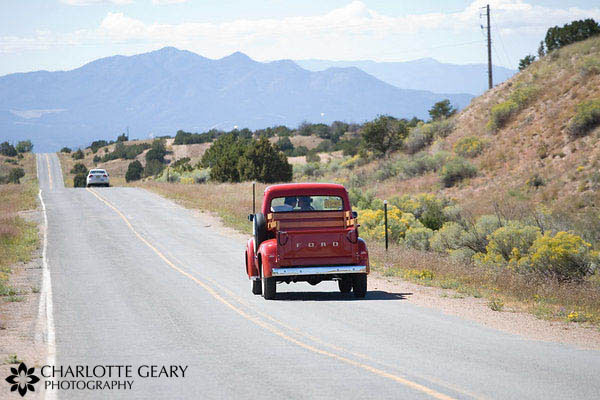Bride and groom leaving in antique red truck