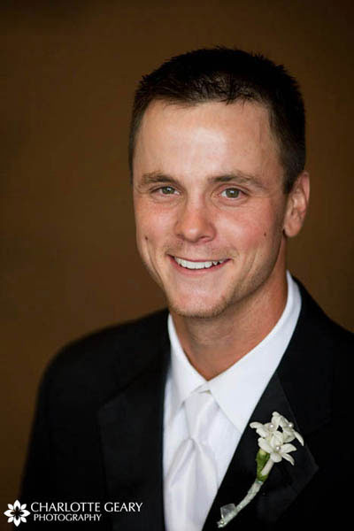 Groom with white tie and white stephanotis boutonniere
