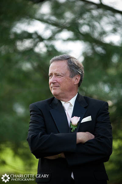Father of the bride in black suit with light pink tie and boutonniere