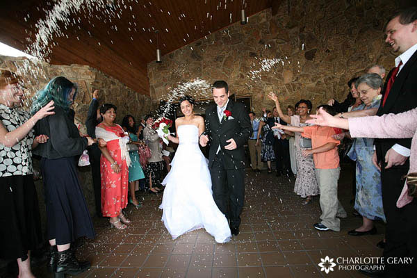 Guests tossing rice as the bride and groom depart