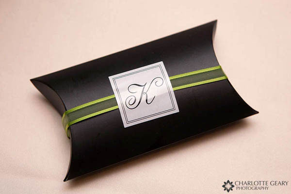 Black wedding favor box with a green ribbon and monogram sticker